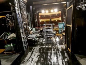 Blick aus dem Bühnenhinterraum in einen beleuchteten Theatersaal